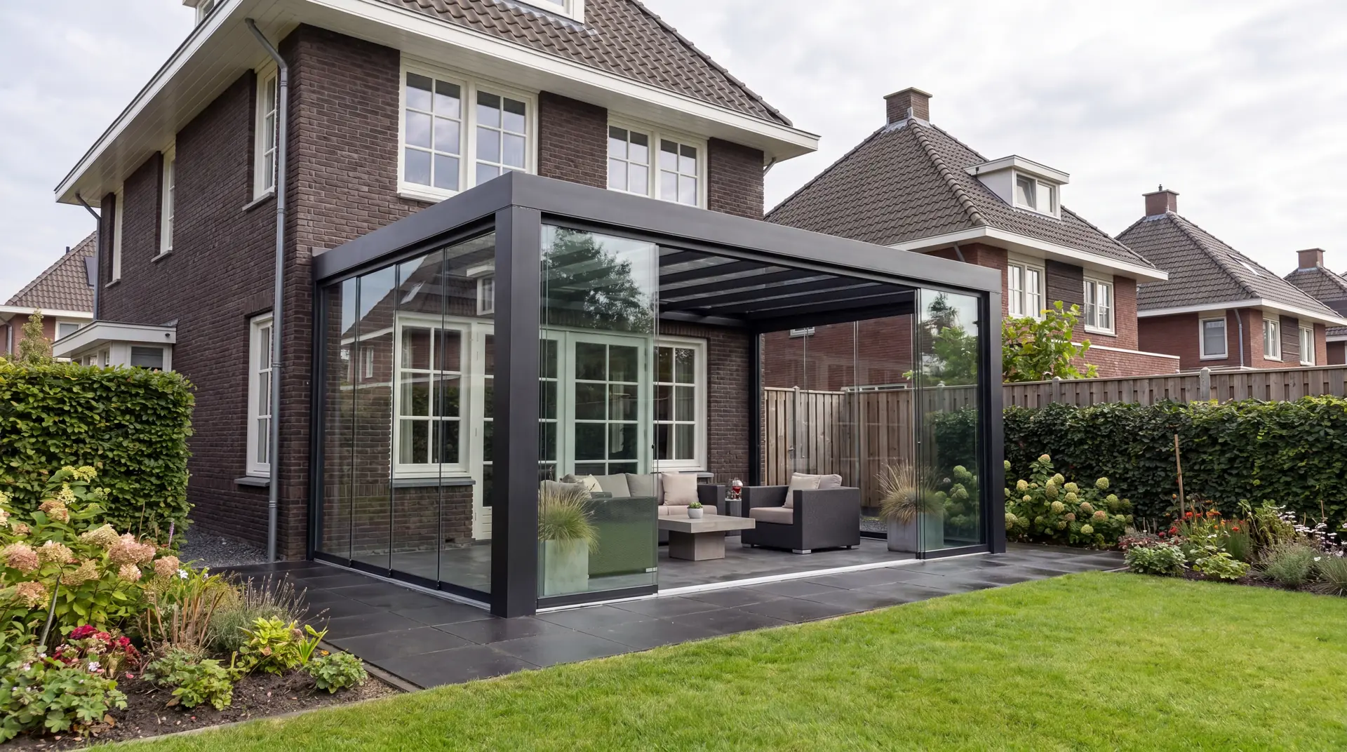 Verandera Majestic tuinkamer in antraciet bij baksteen woning met tuin — extreem sterke aluminium tuinkamer