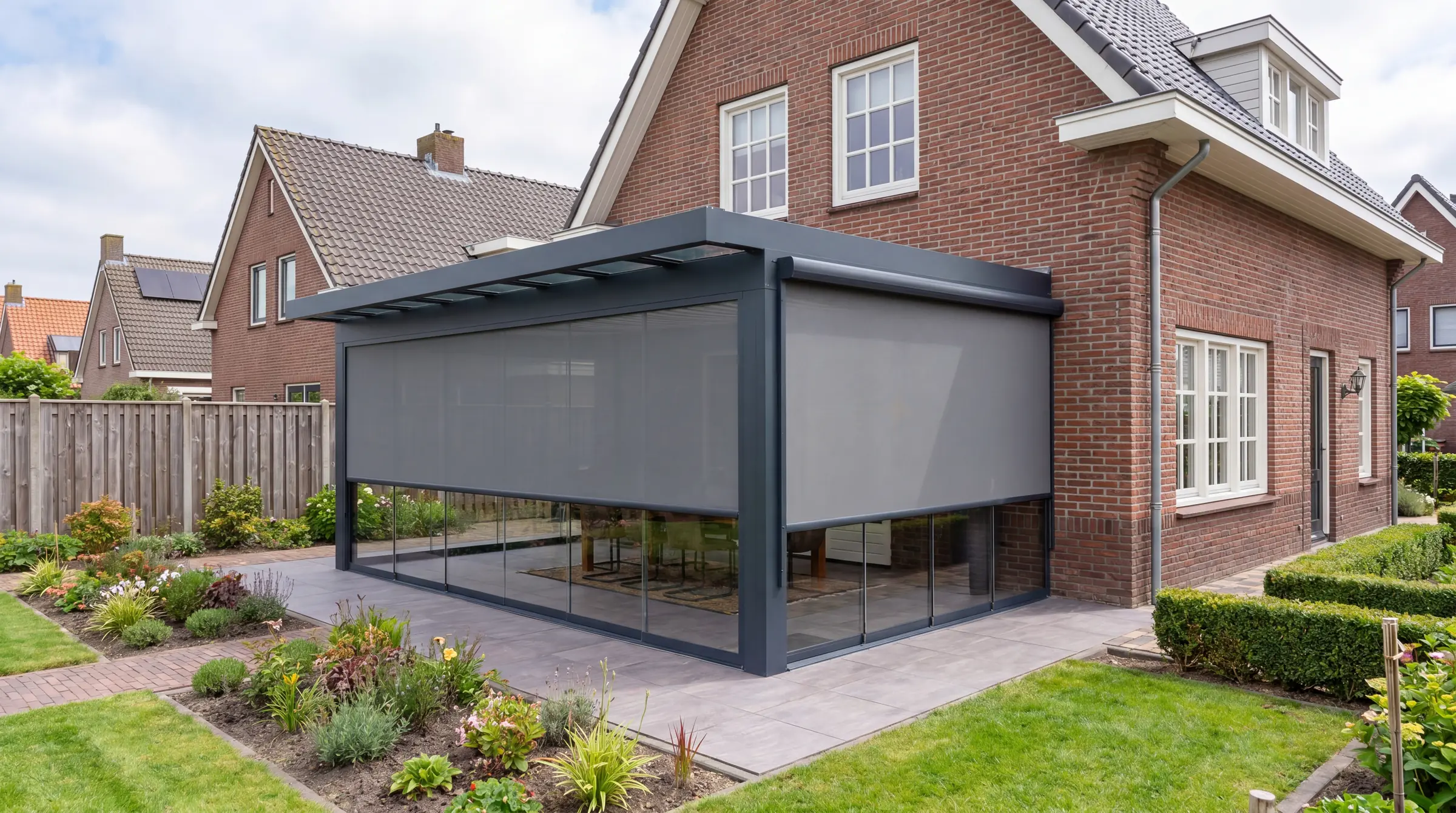 Verandera screens in antraciet aan voor- en zijkant van veranda bij klassieke bakstenen woning — verticale zonwering tegen warmte en zonlicht